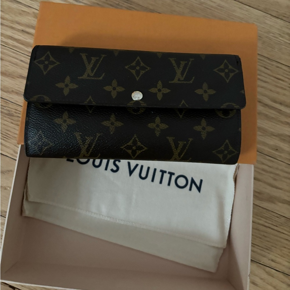 This is an authentic LOUIS VUITTON
Monogram Sarah Wallet.